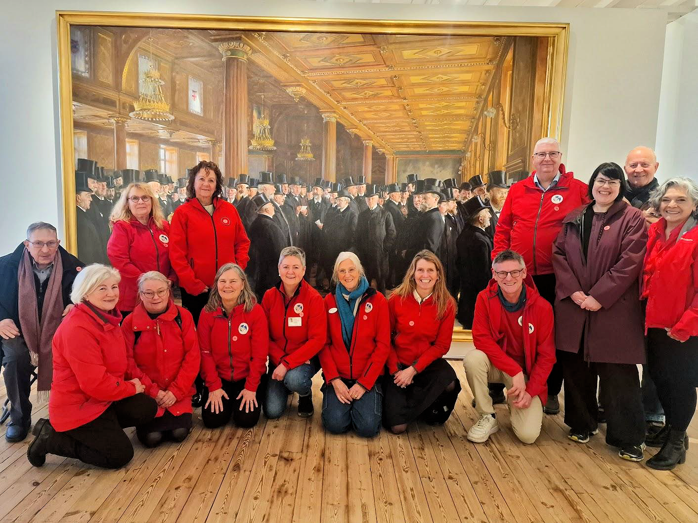 Die rot gekleideten Reiseführer von Odense Tour Guides vor Krøyers Gemälde „Von der Kopenhagener Börse“
